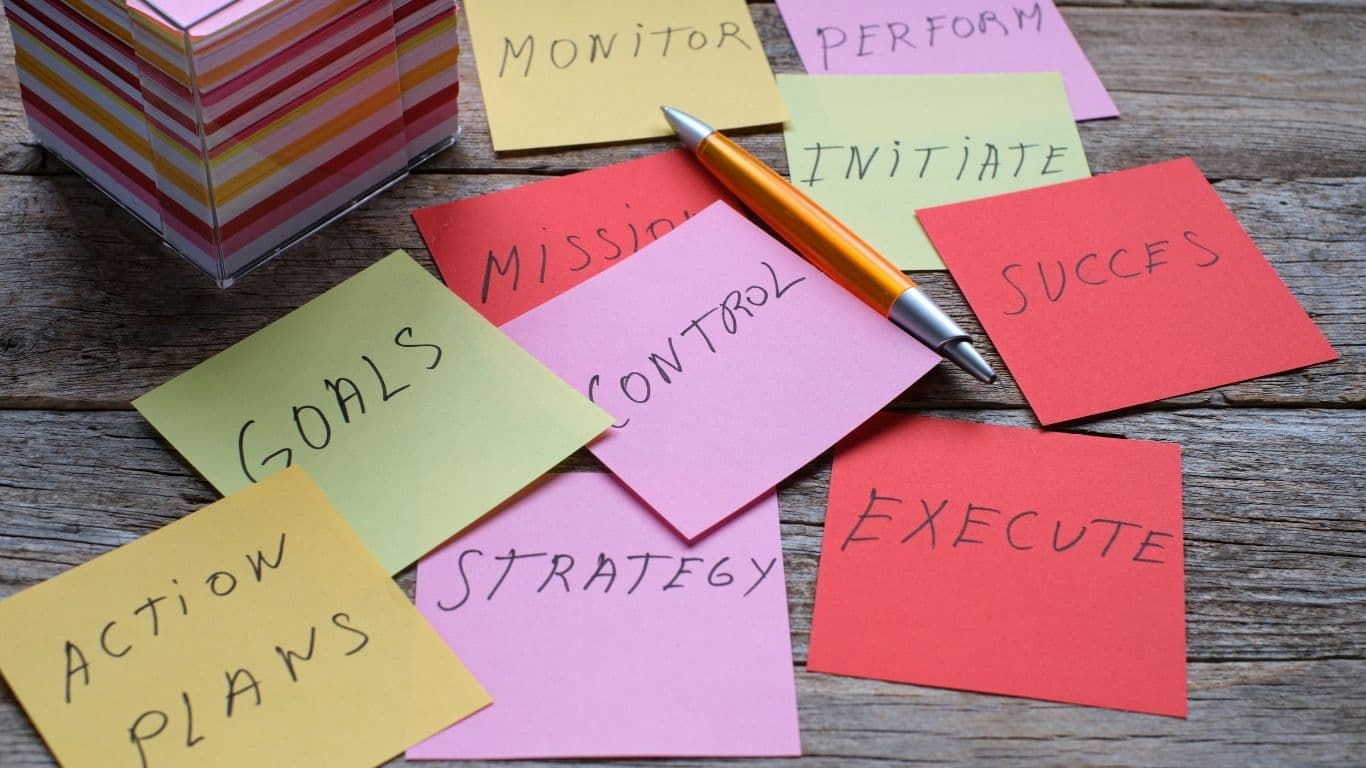 Sticky notes spread across a workspace with strategy and planning words.